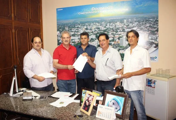 Lideranças recebem das mãos de Geraldo uma cópia da ordem de empenho do recurso que será usado para drenagem e asfalto em Itaporã.